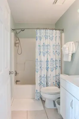 a bathroom with a toilet and a shower curtain at You are my Sunshine- Heated Pool- Steps to sand in Santa Rosa Beach