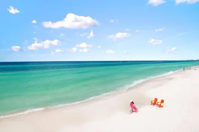 a group of people sitting on a beach at Gulf-Front Paradise, Steps to Beach & Pool Access in Panama City Beach