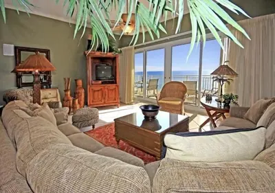 a living room with a couch and a tv and some chairs at Gulf-Front Paradise, Steps to Beach & Pool Access in Panama City Beach