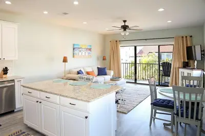 a kitchen and living room with a couch and a table at 2 The Sea- Private Beach- Pool in Santa Rosa Beach