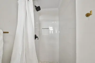 a shower with a white shower curtain in a bathroom at Beachside Villa 811 in Santa Rosa Beach