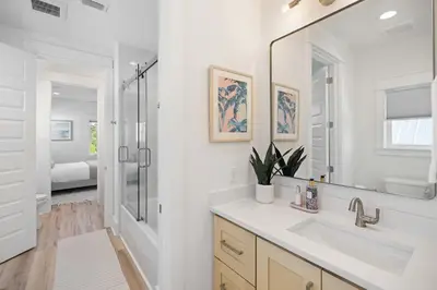 a white bathroom with a sink and a mirror at 30A Retreat - Patio Shared Pool in Inlet Beach