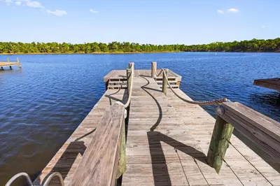 a dock on a lake with benches on it at 30A Retreat - Patio Shared Pool in Inlet Beach