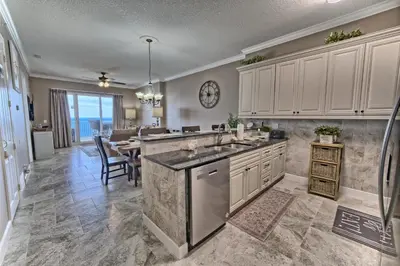 a kitchen with white cabinets and a dining room at Ocean Reef in Panama City Beach