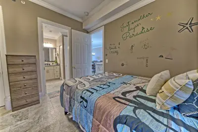 a bedroom with a bed and a wall with a sign on it at Ocean Reef in Panama City Beach
