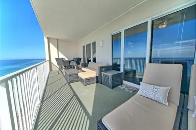 a balcony with a couch and chairs and the ocean at Ocean Reef in Panama City Beach
