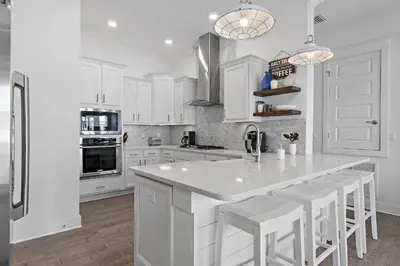 a kitchen with white cabinets and a large white island at UPDATED unit in Prominence - Resort Pool, Golf Cart on 30A in Watersound, FL in Inlet Beach