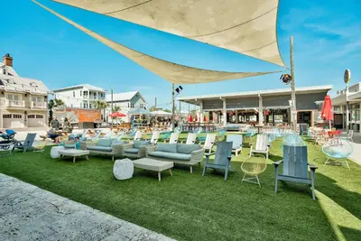 a group of chairs and tables on the grass at UPDATED unit in Prominence - Resort Pool, Golf Cart on 30A in Watersound, FL in Inlet Beach