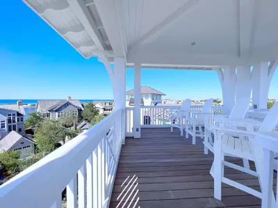 a porch with white chairs and a view of the ocean at Watersound 13 in Watersound Beach