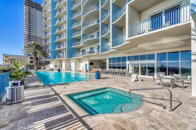 a swimming pool in front of a building at Sterling Breeze 607 | Gulf-Front 3BR Condo | 6th Floor Balcony, Infinity Pool, Direct Beach Access in Panama City Beach