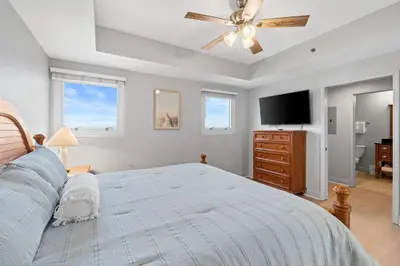 a bedroom with a bed and a ceiling fan at Sterling Breeze 607 | Gulf-Front 3BR Condo | 6th Floor Balcony, Infinity Pool, Direct Beach Access in Panama City Beach