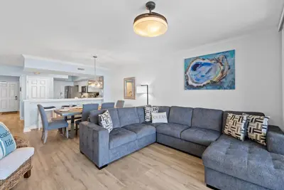 a living room with a couch and a table at Emerald Beach 1736 by Emerald Coast Retreats in Panama City Beach