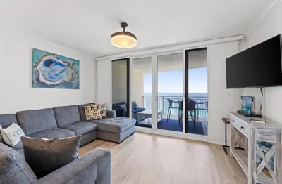 a living room with a couch and a television at Emerald Beach 1736 by Emerald Coast Retreats in Panama City Beach