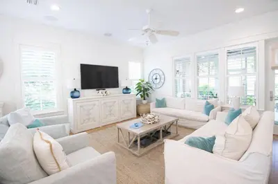 a living room with white furniture and a flat screen tv at Second Star Shores in Watersound Beach