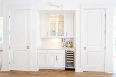 a kitchen with white cabinets and a counter with two doors at Second Star Shores in Watersound Beach