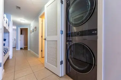 a hallway with two washing machines on the wall at Seychelles 407 in Panama City Beach