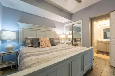 a bedroom with a large bed and a mirror at Seychelles 407 in Panama City Beach