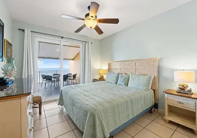 a bedroom with a bed with a ceiling fan at Sterling Reef 104 in Panama City Beach