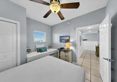a bedroom with a bed and a ceiling fan at Sterling Reef 104 in Panama City Beach