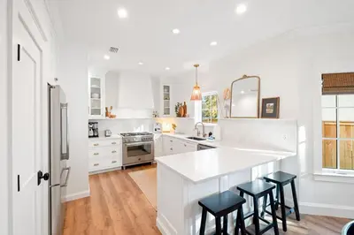 a white kitchen with a counter and stools in it at Private Pool, Impulse Buy The Sea, Sleeps 13, Beach Access in Inlet Beach