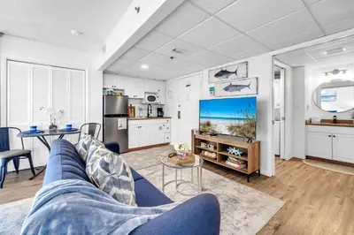 a living room with a blue couch and a kitchen at Long Beach Resort 1-1300E in Panama City Beach
