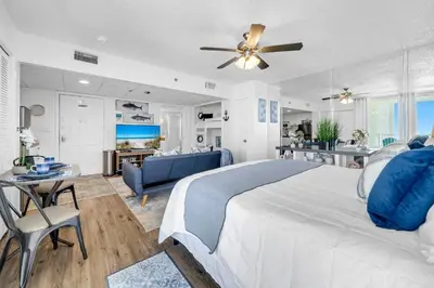 a bedroom with a large bed and a living room at Long Beach Resort 1-1300E in Panama City Beach