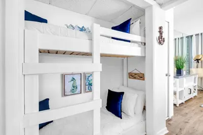 a bedroom with two bunk beds with blue pillows at Long Beach Resort 1-1300E in Panama City Beach