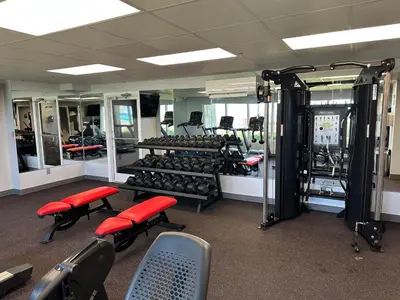 a gym with a lot of equipment and red chairs at Long Beach Resort 1-1300E in Panama City Beach
