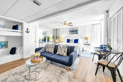 a living room with a bed and a blue couch at Long Beach Resort 1-1300E in Panama City Beach