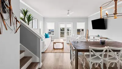 a dining room and living room with a table and chairs at Salty Seabreeze in Seacrest