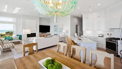 a kitchen and living room with a table and chairs at Camelot in Seagrove Beach