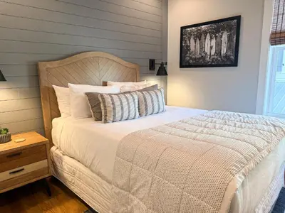 a bedroom with a white bed with a wooden headboard at Bella Sol by 30A Escapes in Rosemary Beach