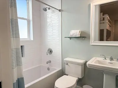 a white bathroom with a toilet and a sink at Bella Sol by 30A Escapes in Rosemary Beach