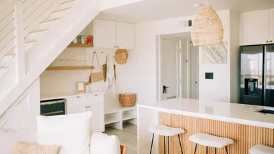 a kitchen with white cabinets and a kitchen island with stools at 2 Condos Steps to Beach Ocean View Heated Pool The Sea Chord Salt Haus in Watersound Beach