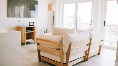 a couch in a living room with a window at 2 Condos Steps to Beach Ocean View Heated Pool The Sea Chord Salt Haus in Watersound Beach