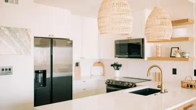 a kitchen with white cabinets and a black refrigerator at 2 Condos Steps to Beach Ocean View Heated Pool The Sea Chord Salt Haus in Watersound Beach