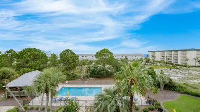 an aerial view of a resort with a swimming pool and palm trees at 2 Condos Steps to Beach Ocean View Heated Pool The Sea Chord Salt Haus in Watersound Beach