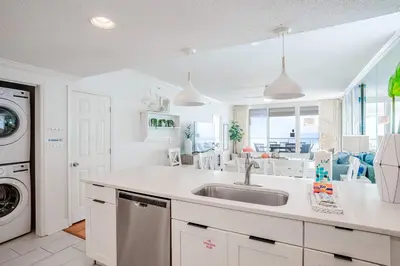 a white kitchen with a sink and a dishwasher at Majestic Sunset For 11 in Panama City Beach