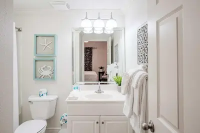 a bathroom with a sink and a toilet and a mirror at Majestic Sunset For 11 in Panama City Beach