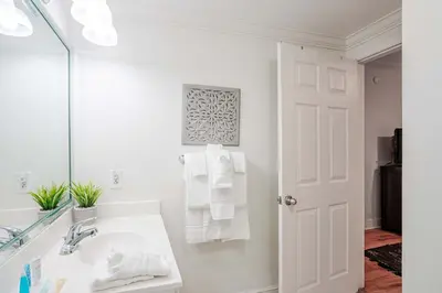 a white bathroom with a sink and a mirror at Majestic Sunset For 11 in Panama City Beach