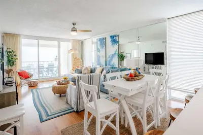 a living room with a table and a couch at Majestic Sunset For 11 in Panama City Beach