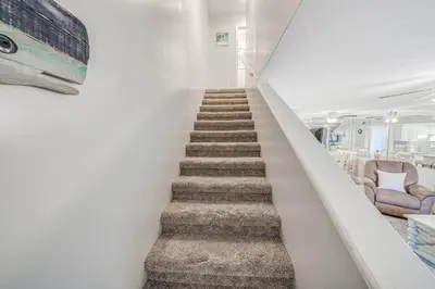 a stairway leading up to a room with chairs at Resort Townhome with Free Golf Cart in Panama City Beach