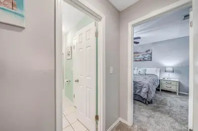 a bedroom with a bed and a door leading into a room at Resort Townhome with Free Golf Cart in Panama City Beach