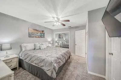 a bedroom with a bed and a ceiling fan at Resort Townhome with Free Golf Cart in Panama City Beach