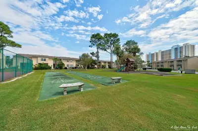 a park with two benches and a playground at Resort Townhome with Free Golf Cart in Panama City Beach