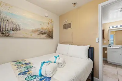 a bedroom with a bed with towels on it at Come visit Sophomore! 2BR 2BA Beachfront Condo! Sleeps 5! in Panama City Beach