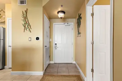 a hallway with a white door and yellow walls at Come visit Sophomore! 2BR 2BA Beachfront Condo! Sleeps 5! in Panama City Beach