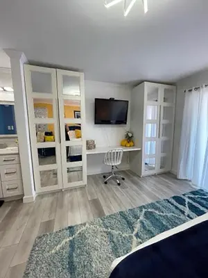 a bedroom with white cabinets and a desk with a television at Seagull Villas #3 by Emerald Coast Retreats in Panama City Beach
