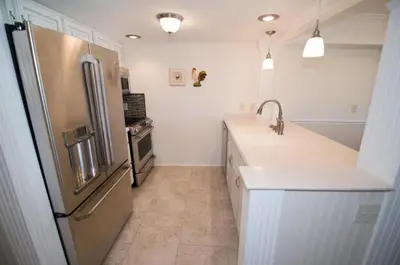 a kitchen with a stainless steel refrigerator and white cabinets at Seagull Villas #7 by Emerald Coast Retreats in Panama City Beach