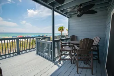 a porch with a table and chairs and the beach at Seagull Villas #7 by Emerald Coast Retreats in Panama City Beach